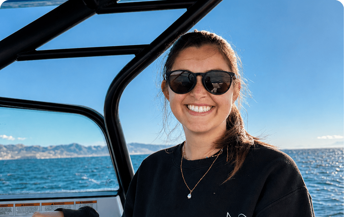 Smiling person wearing sunglasses on a boat.