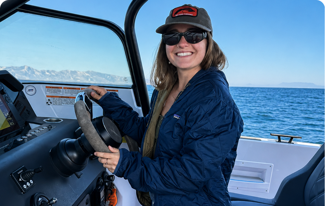 Person steering boat on sunny day.